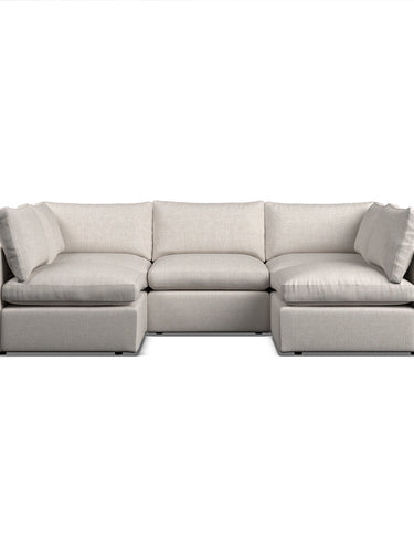 A modern modular sofa, arranged in a u shape configuration in a natural coloured fabric with basketweave texture